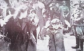 תמונת הילד המרים ידיים בגטו ורשה, שפורסמה ב''הקהילה''. פני האשה שלידו מטושטשים