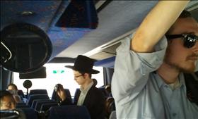 צעיר חרדי משכנע להניח תפילין באוטובוס. צילום'' עידו קינן (פורסם לראשונה במוסף ''הארץ'')