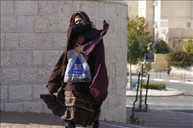 אישה חרדית בבית שמש עטופה שכבות ביגוד רבות ורעלה. צילום: מיכל פתאל, פלאש 90