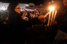 חברת מועצת עיריית ירושלים, רחל עזריה, מדליקה נרות באירוע מחאה נגד התחרדות הכותל. חנוכה תש